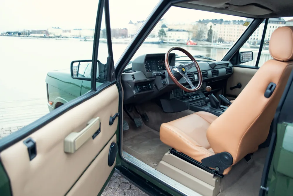 Vintage car interior with open door waterfront
