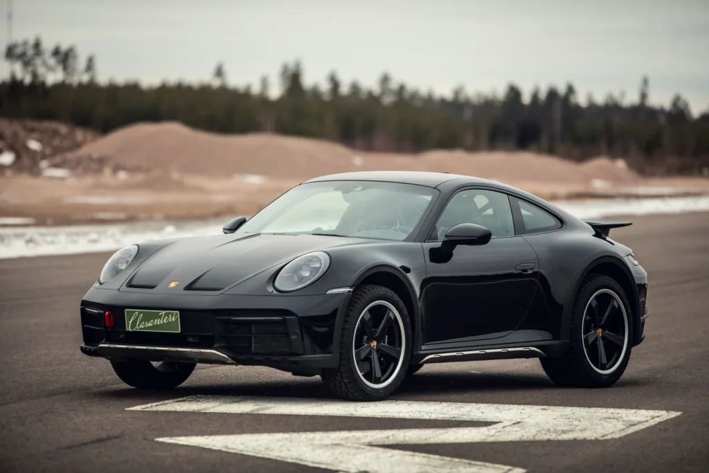 Black sports car on asphalt road.