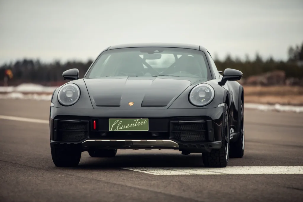 Black sports car on road, front view.