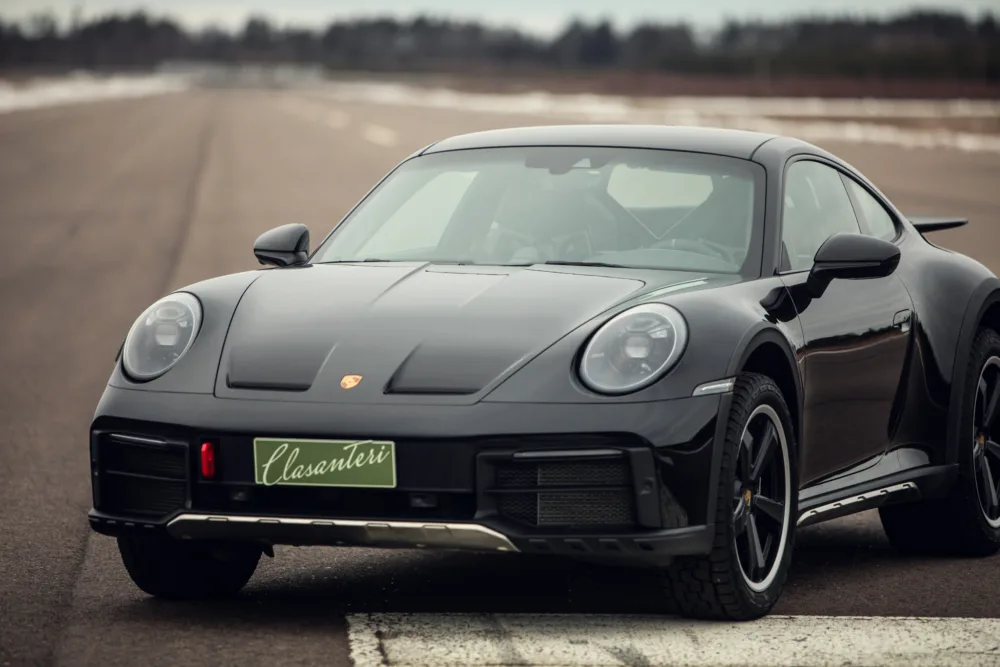 Black Porsche sports car on road.
