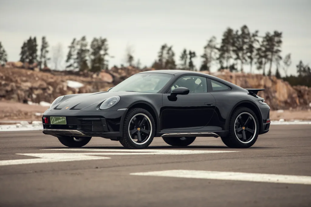 Black sports car parked on asphalt road.