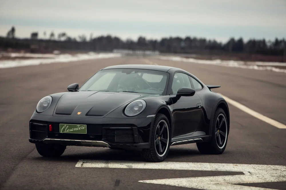 Black Porsche 911 on tarmac road.