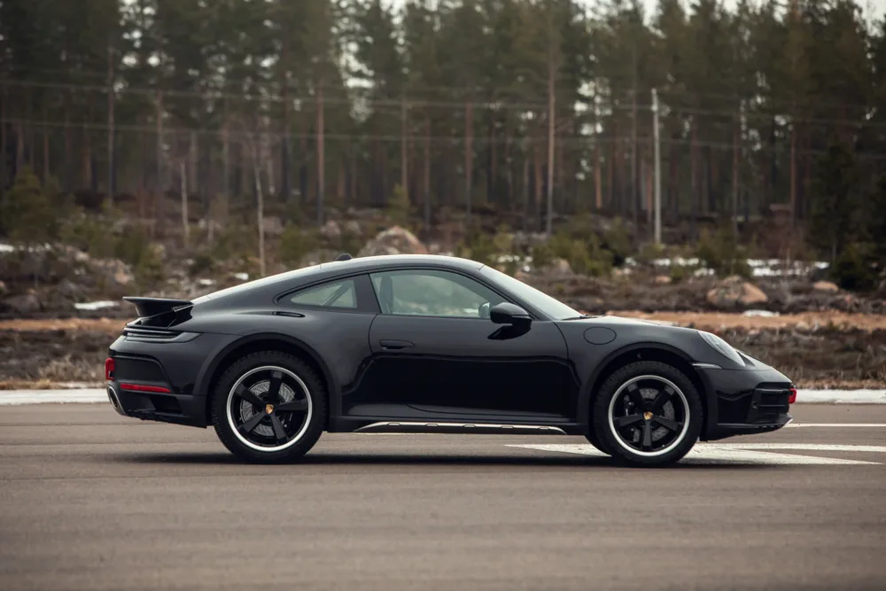 Black sports car parked on an empty road.