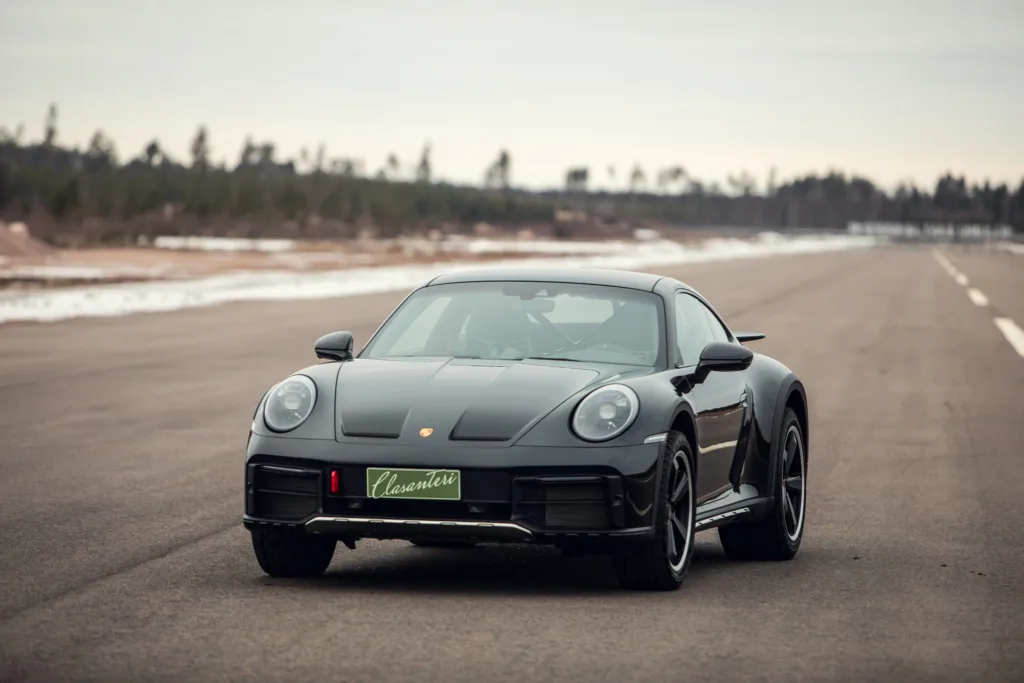 Black sports car on empty tarmac road.
