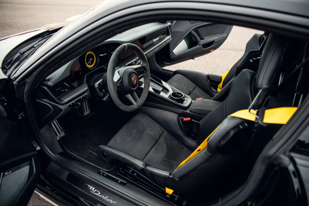 Sporty luxury car interior with black and yellow accents.