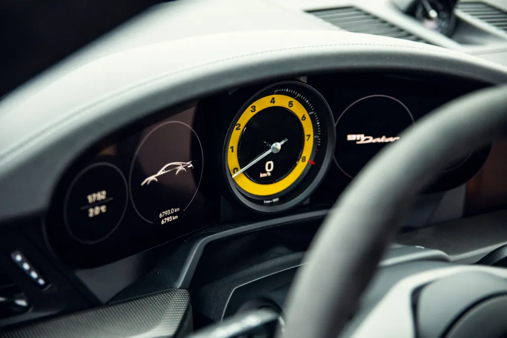 Modern car dashboard with rev counter and speedometer.