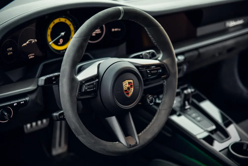 Luxury car steering wheel and dashboard interior.