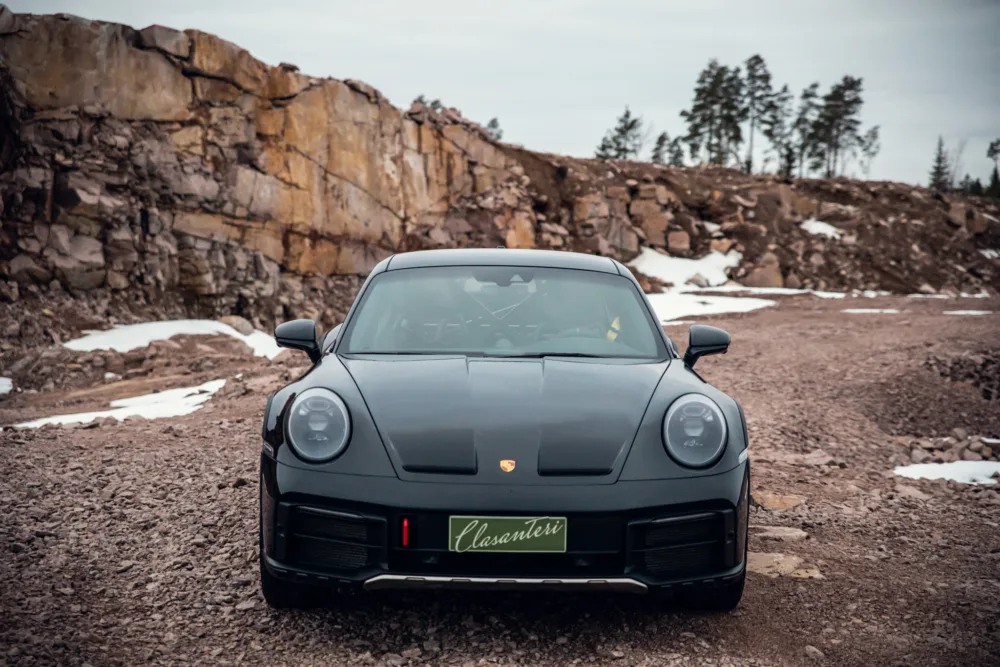 Black sports car in rocky terrain.