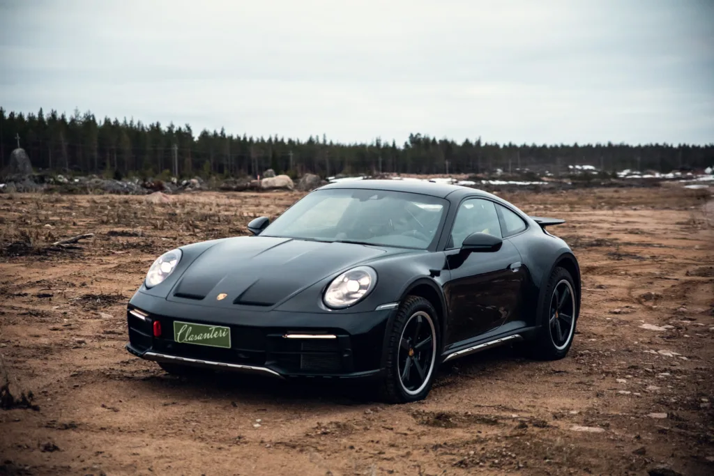 Black sports car parked on barren landscape.