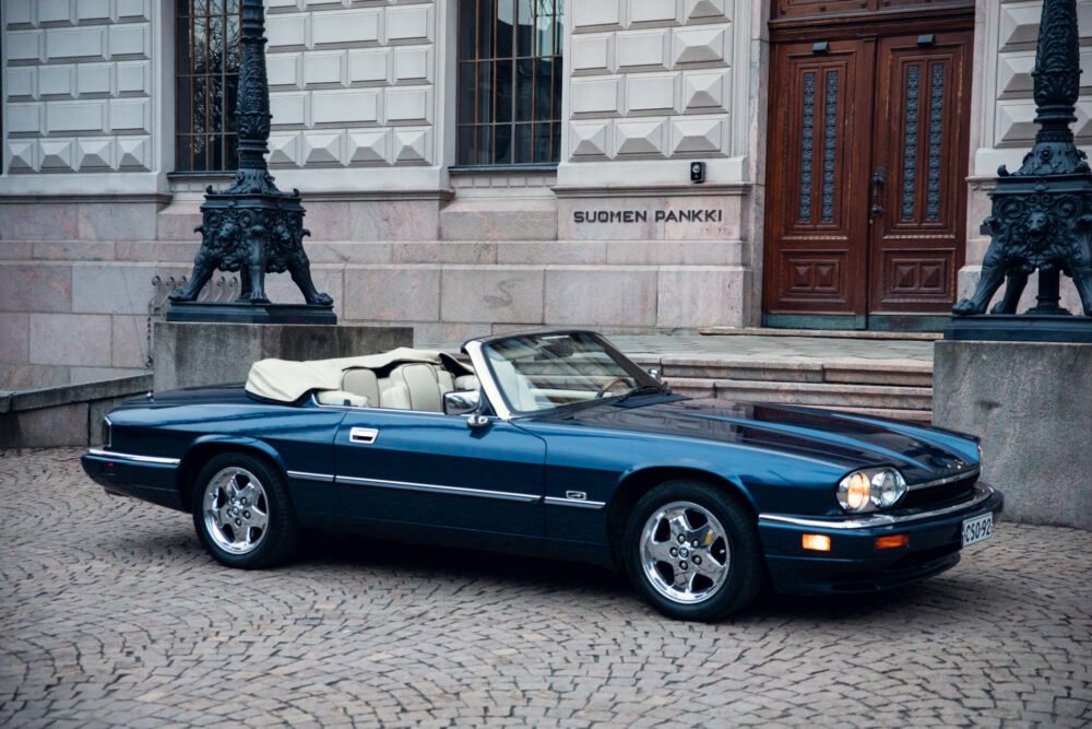 Classic blue convertible car in front of Suomen Pankki.