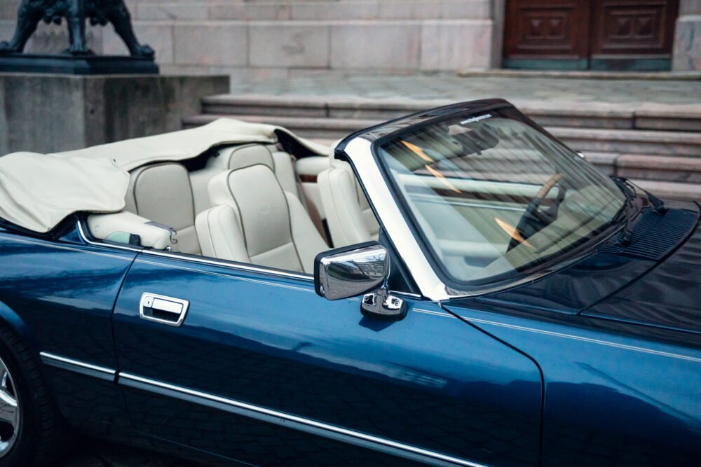 Blue convertible classic car parked with beige interior.