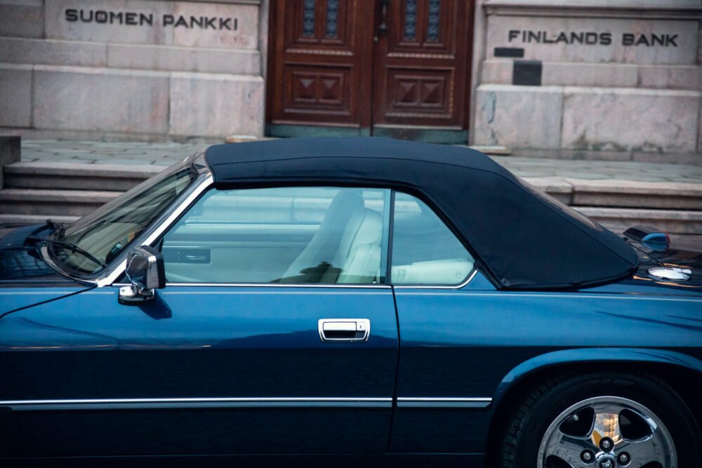Blue convertible car parked in front of Finland's Bank.