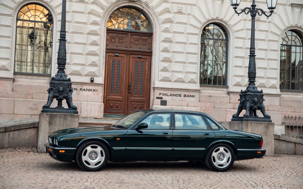 Green Jaguar car parked outside Finland's Bank.