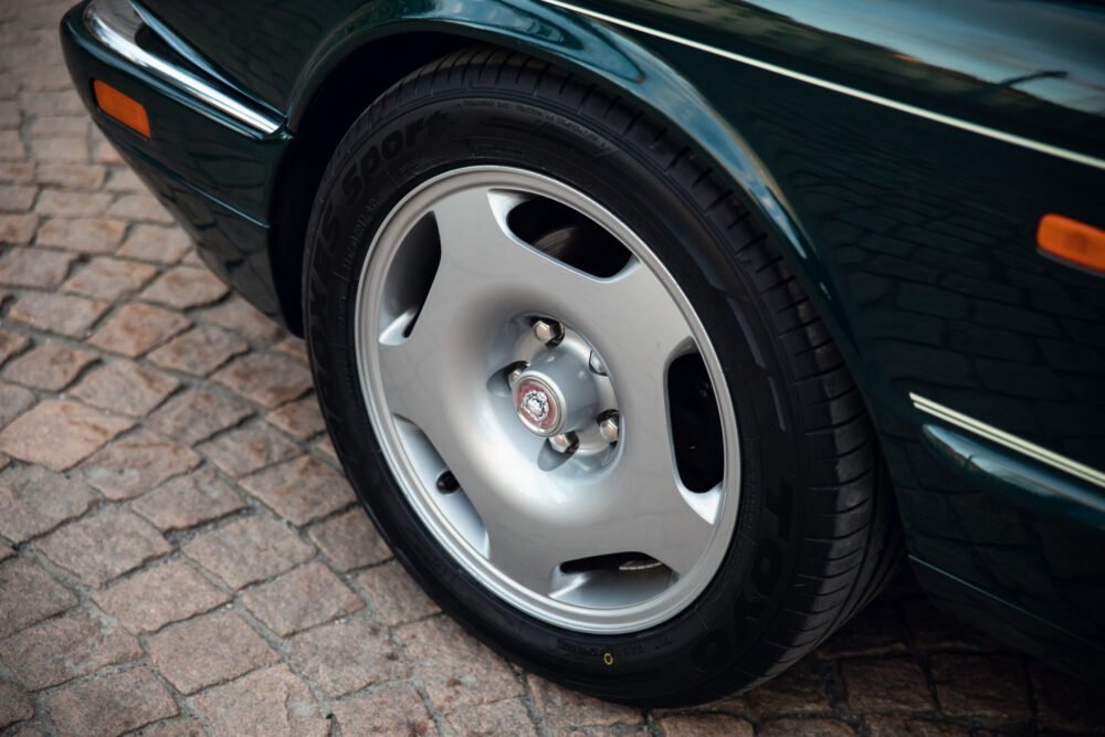 Close-up of classic car wheel on cobblestone.