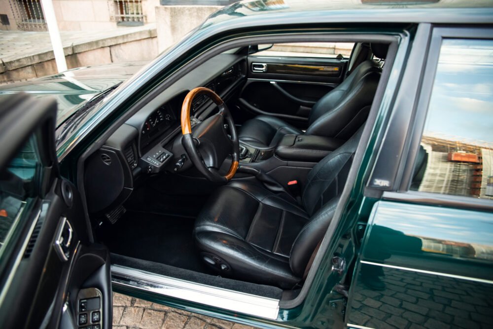 Luxury car interior with wooden steering wheel.