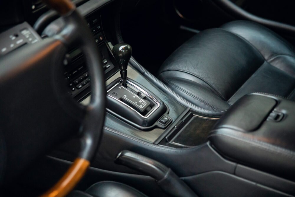 Black leather car interior with gear shift and dashboard