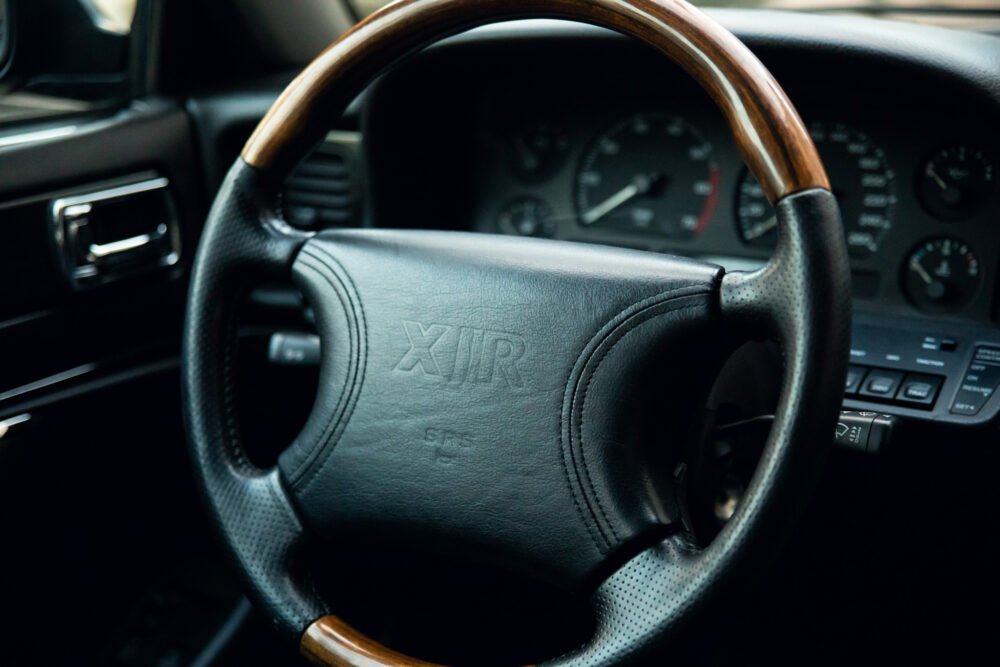 Vintage car steering wheel and dashboard detail.