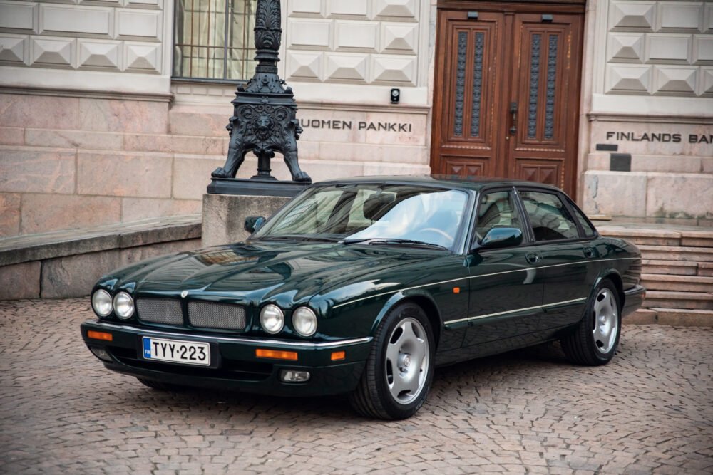 Green Jaguar sedan parked outside Finland's Bank.