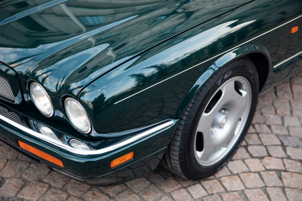Green Jaguar car front close-up, chrome details.