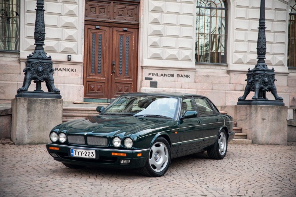 Vintage green Jaguar parked in front of Finland's Bank.