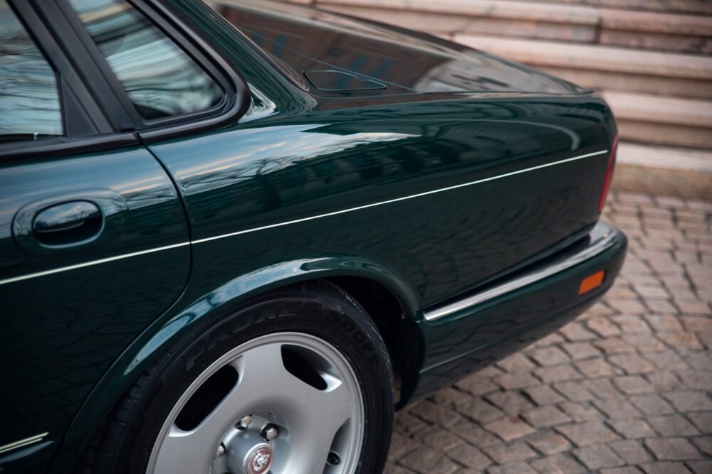 Green classic car close-up, elegant design details.