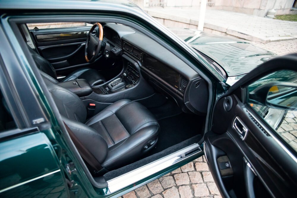 Luxury car interior with leather seats and wooden dashboard.