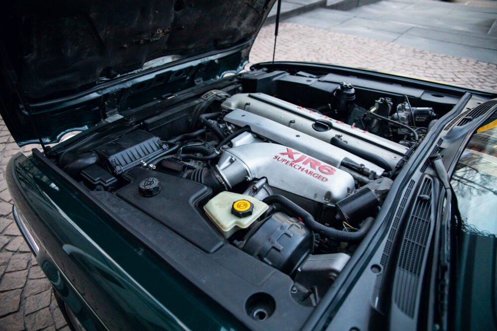 Car engine bay with visible supercharged XR6 motor.