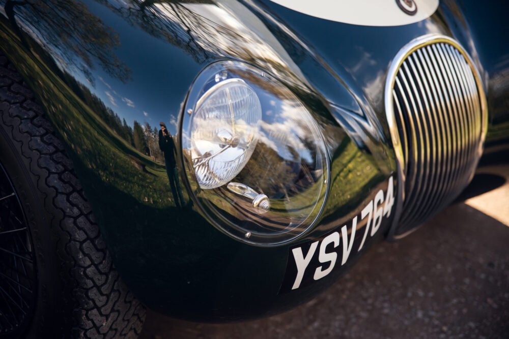 Close-up of vintage car's headlight and grille.