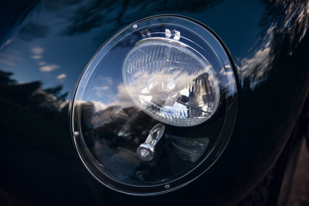 Close-up of a classic car's headlight and chrome detail.