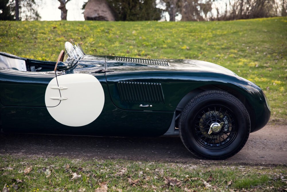 Vintage green sports car with white side circle.