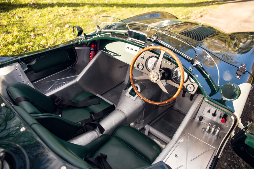 Vintage green roadster interior, wood steering wheel.