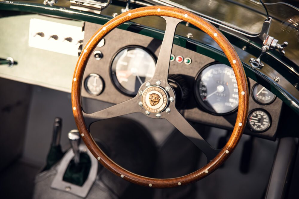 Vintage car dashboard with wooden steering wheel.
