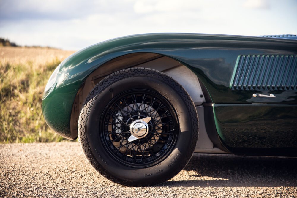 Close-up of vintage green car's wheel and fender.