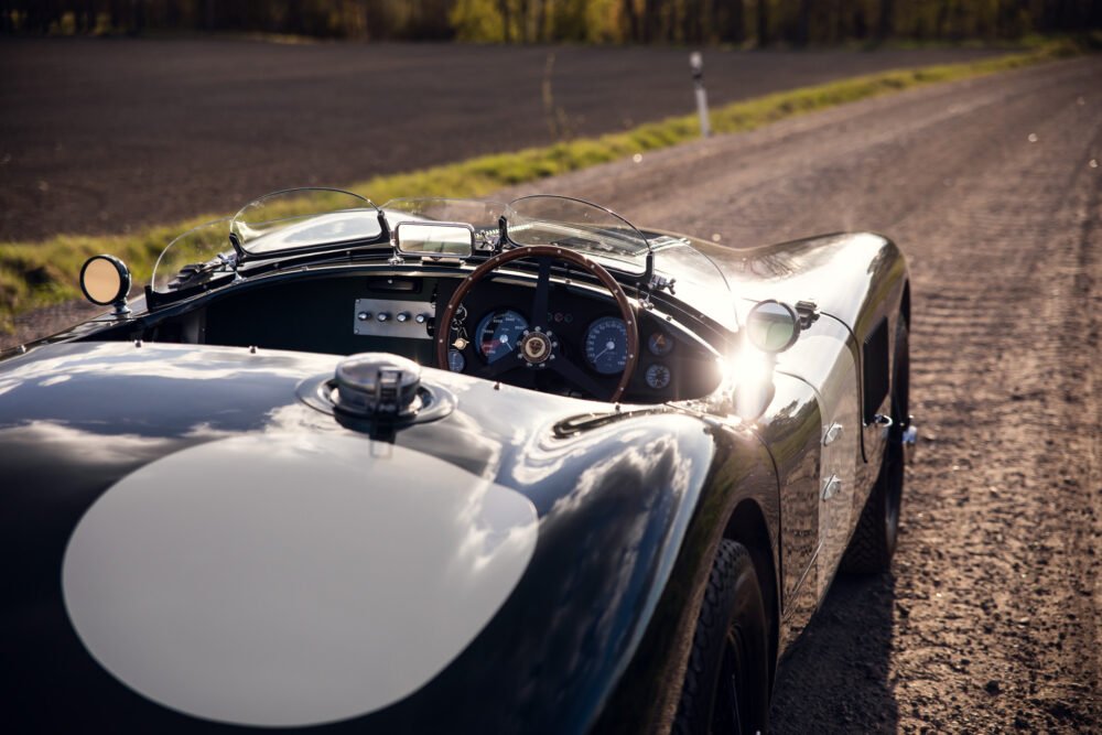 Vintage sports car on sunny country road.