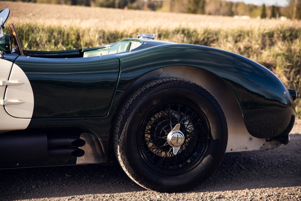 Vintage green sports car on country road.