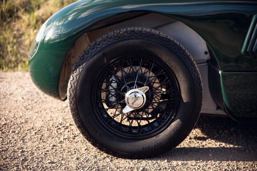 Classic green car's detailed wheel and tire.