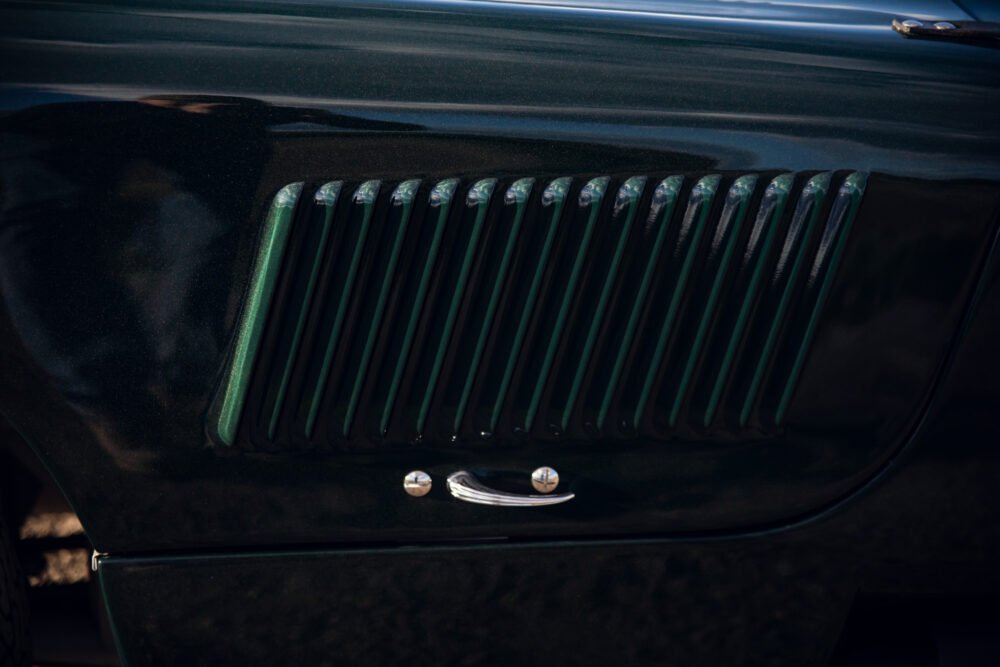Close-up of classic car's dark green side vent.