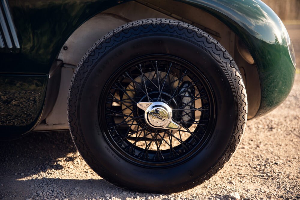 Classic Jaguar wheel with logo in sunlight.