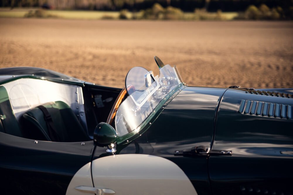 Close-up of classic convertible car's windshield and hood.