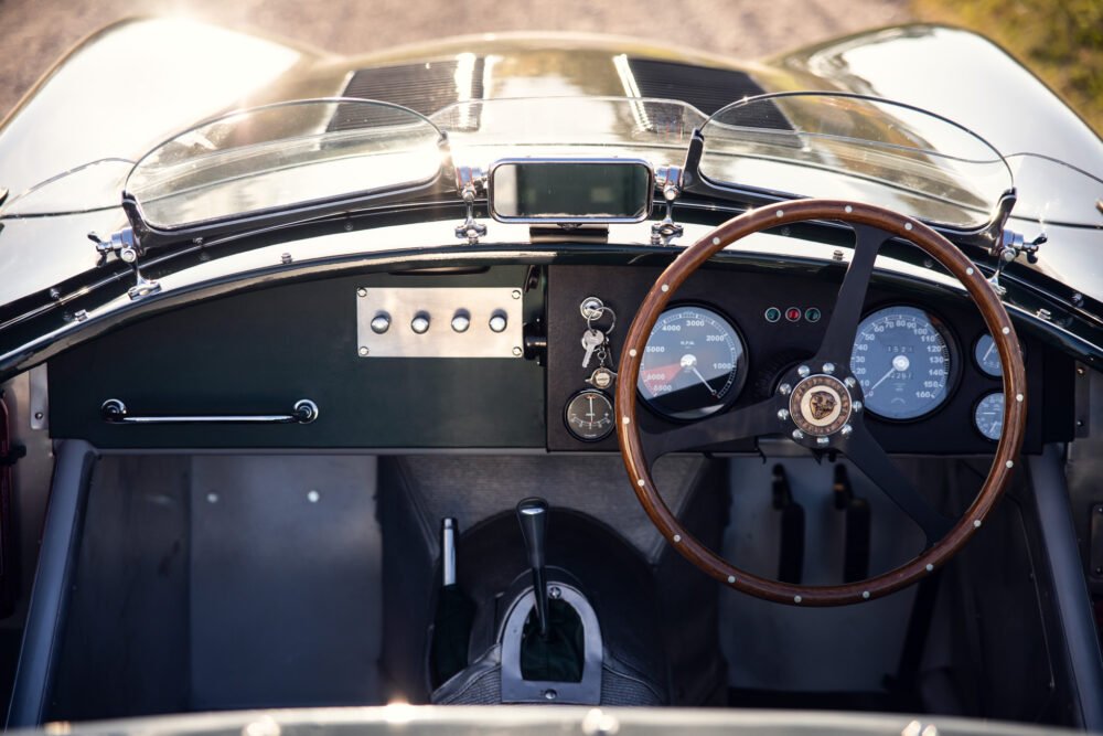 Vintage car dashboard with steering wheel and gauges.