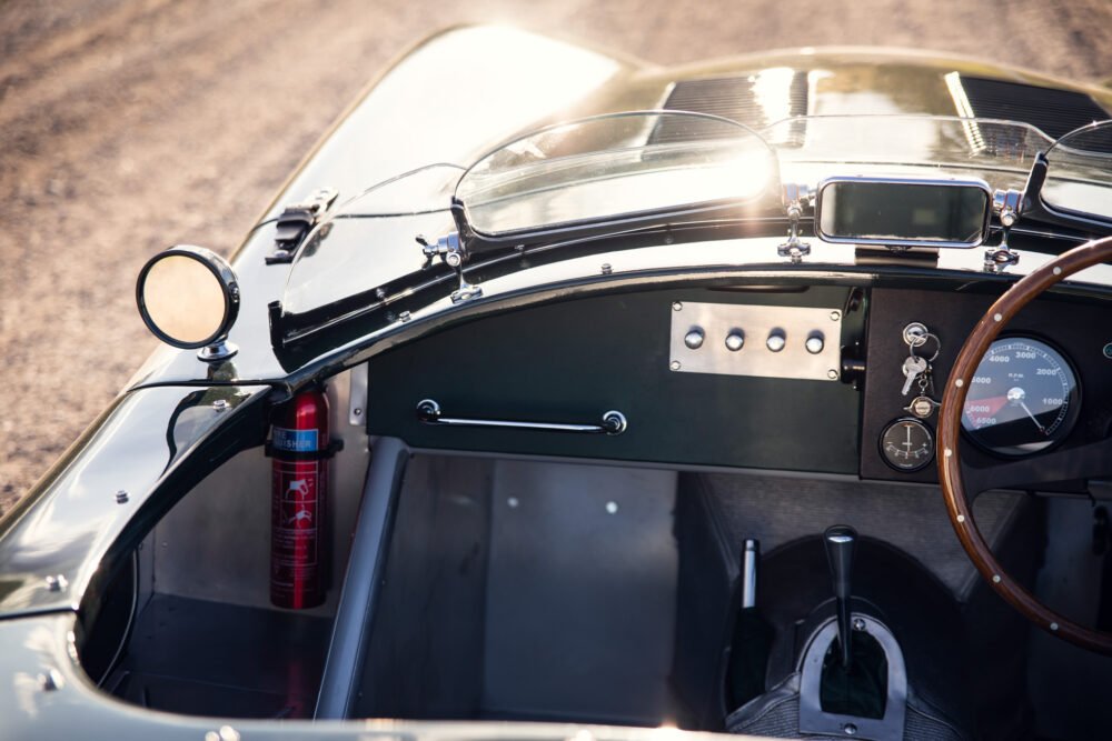 Vintage car dashboard and steering wheel in sunlight.