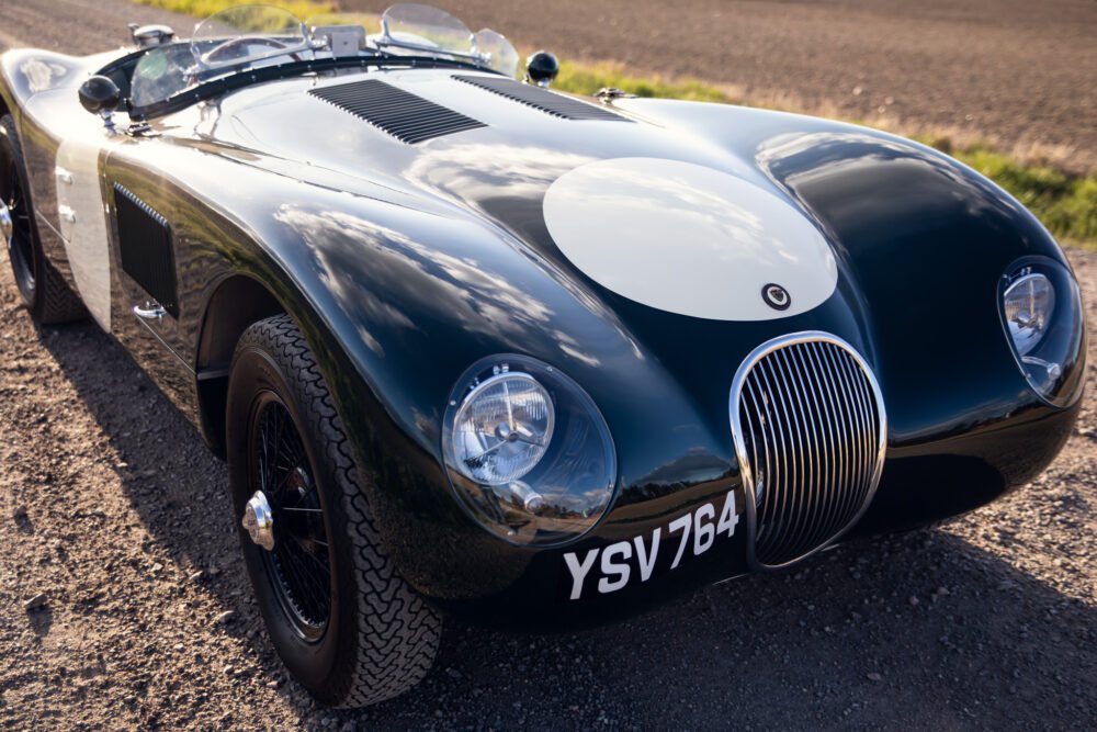 Vintage black Jaguar race car, close-up front view.