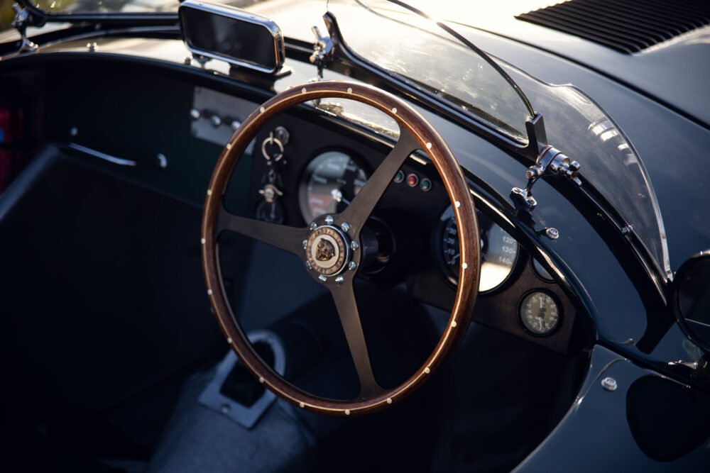 Classic car interior with wooden steering wheel.