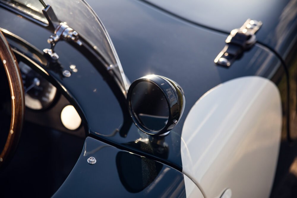 Close-up of vintage car mirror and steering wheel.