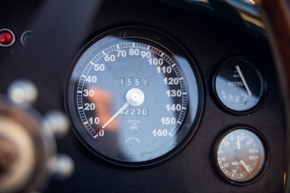 Vintage car speedometer showing speed and fuel levels.