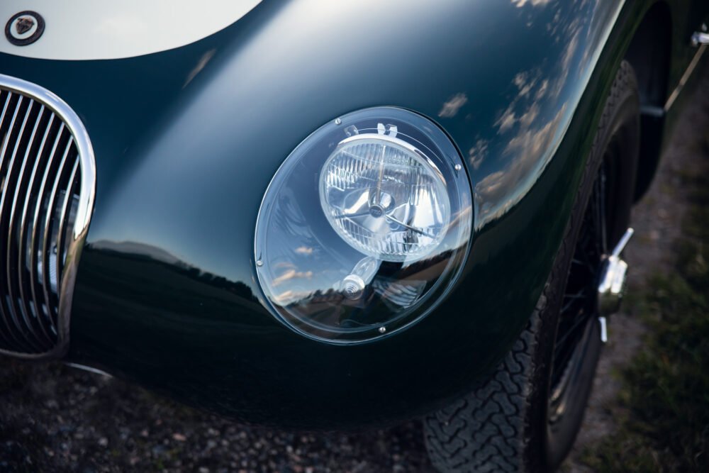 Close-up of vintage car headlight and grille.