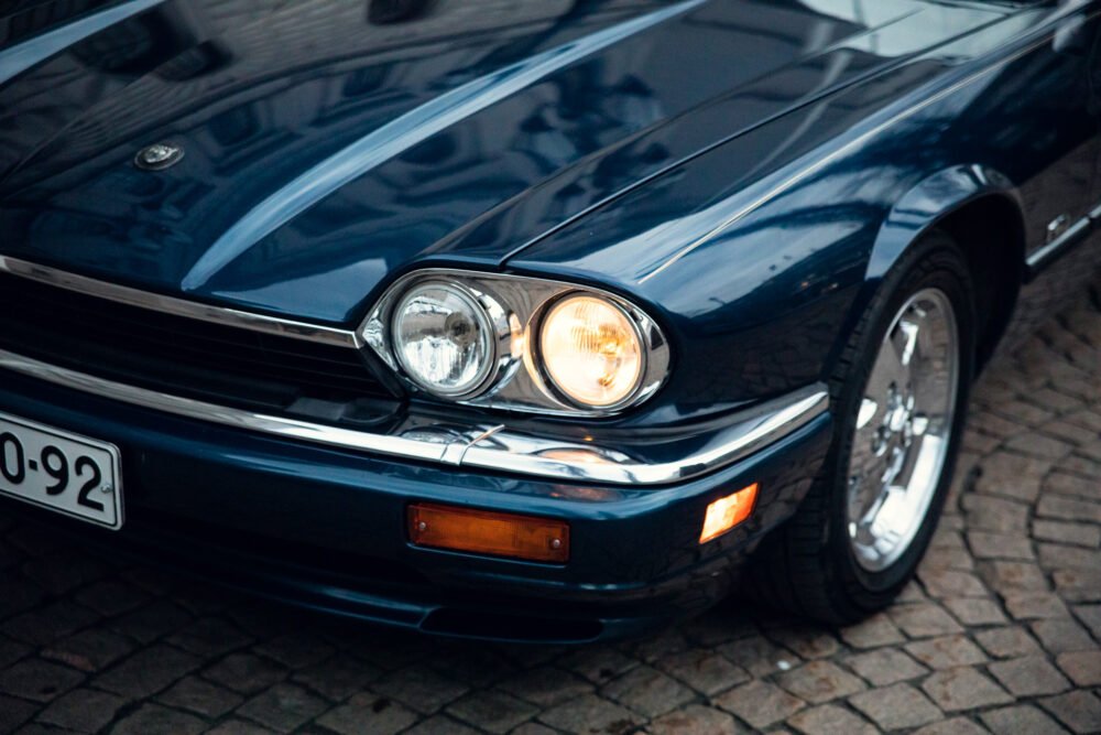 Close-up of classic blue car's front and headlights.