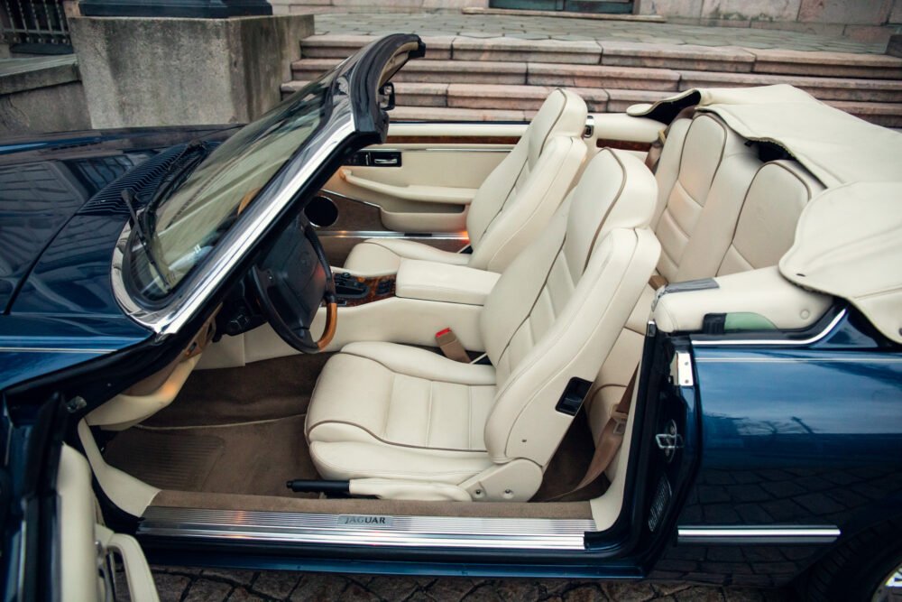 Blue Jaguar convertible with luxurious beige leather interior.