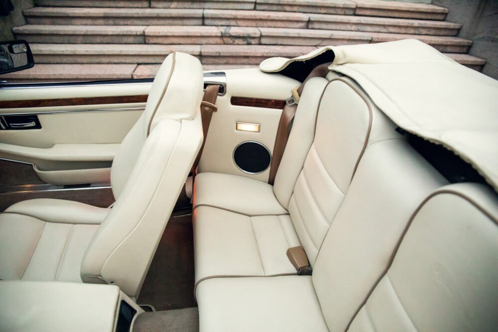 Luxurious car interior with white leather seats.