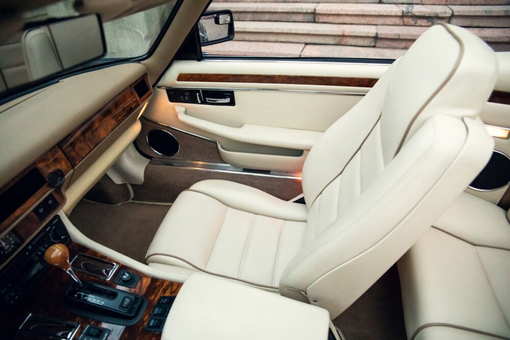 Luxurious car interior with leather seats and wooden accents.